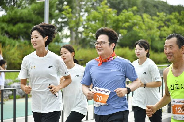 오세란 시청 소속 여자 육상선수 겸 코치와 페이스메이커로 호흡하며 5km 마라톤을 뛰고 있는 김병수 김포시장
