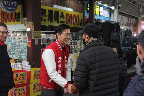 방문규 후보가 수원 남문시장에서 만난 시민과 인사를 나누고 있다.